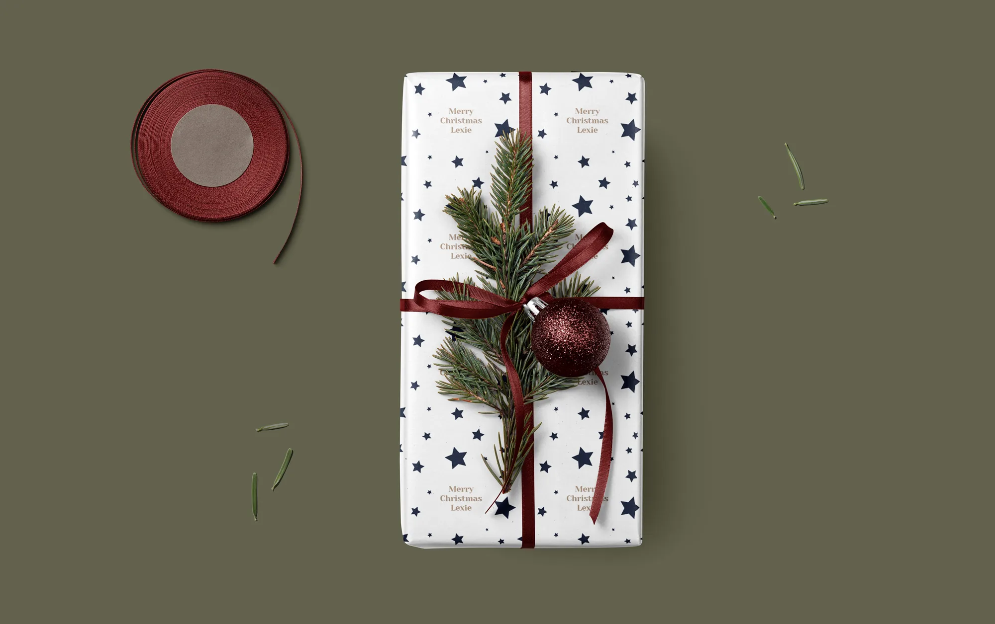 A present wrapped in personalised Christmas paper with a red ribbon